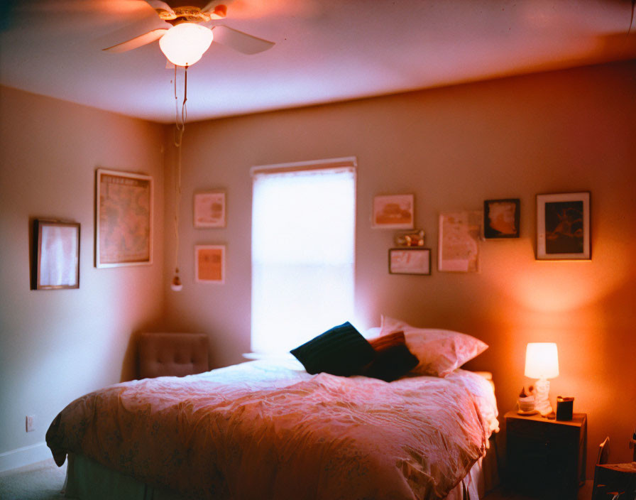 Inviting bedroom with made bed, wall art, ceiling fan, and soft lighting