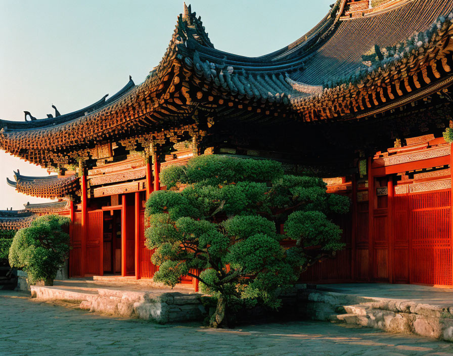 Traditional Korean architecture: intricate roof design, red doors, green foliage, clear blue sky