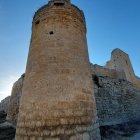 Medieval stone fortress with tall towers and sturdy walls under clear blue sky