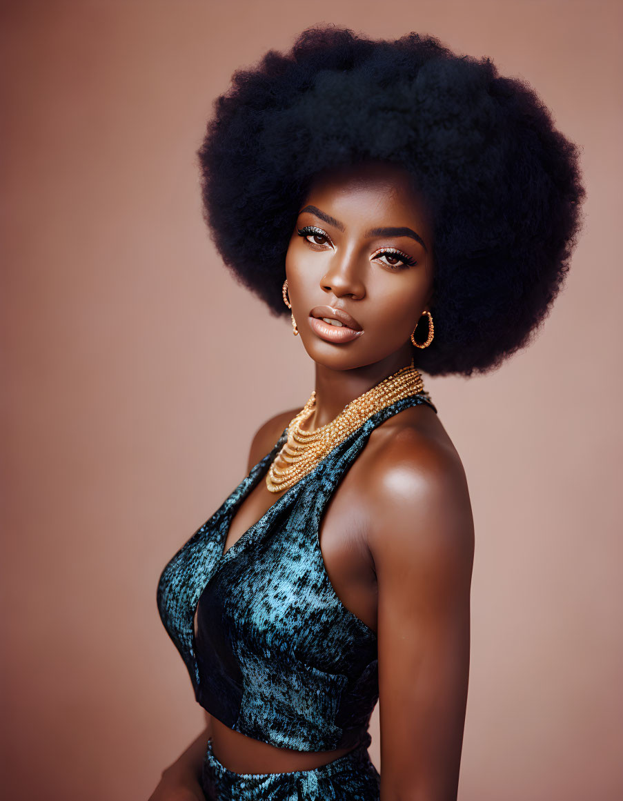 Woman with voluminous afro and blue top on pink background