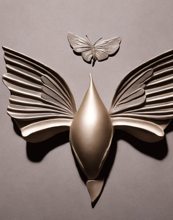 Metallic gold wings and teardrop body create artificial butterfly on grey background