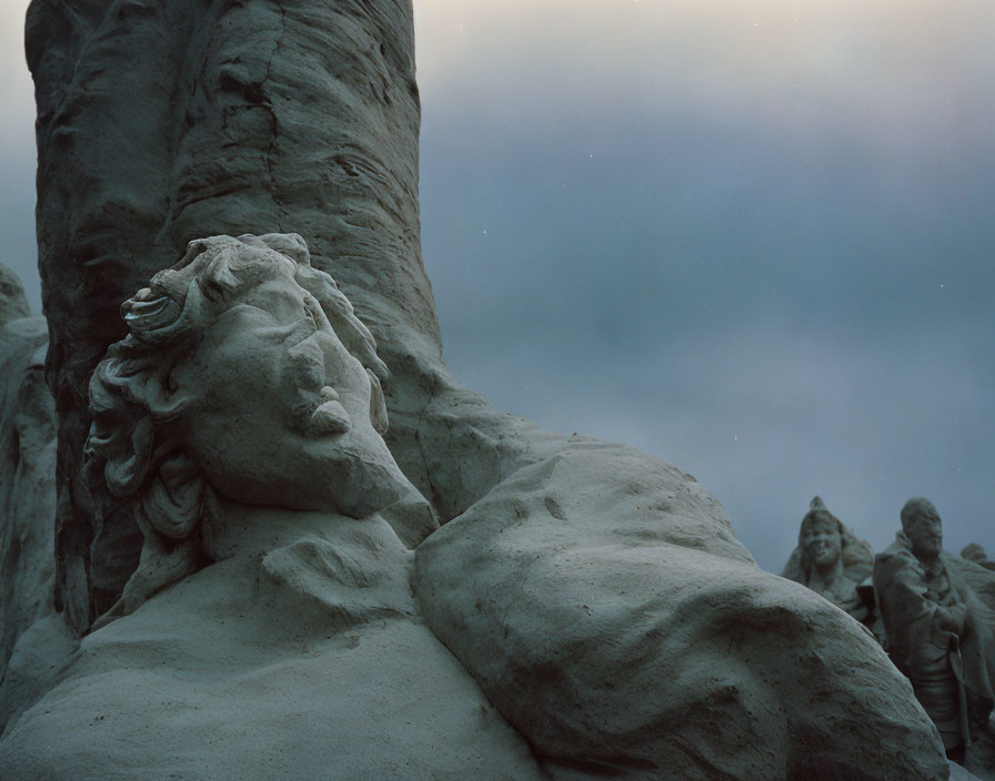 Detailed Sand Sculpture of Reclining Figure with Flowing Hair and Expressive Facial Features