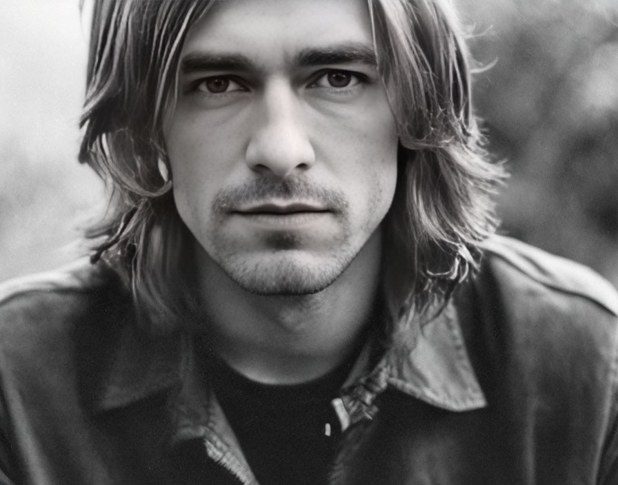 Monochrome portrait of young man with shoulder-length hair and light beard