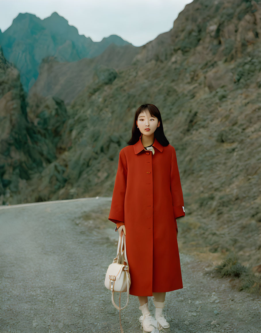 Woman in Red Coat on Mountain Road with White Bag