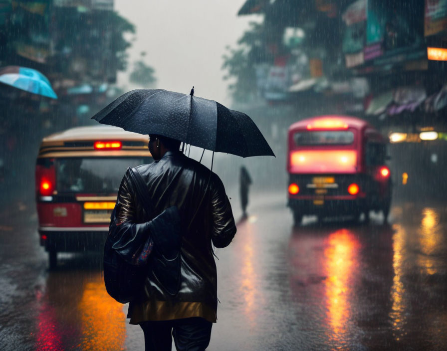 Person with umbrella walking on wet street in rain with blurred buses and shimmering lights.