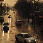 Classic Cars Drive on Wet Street at Dusk