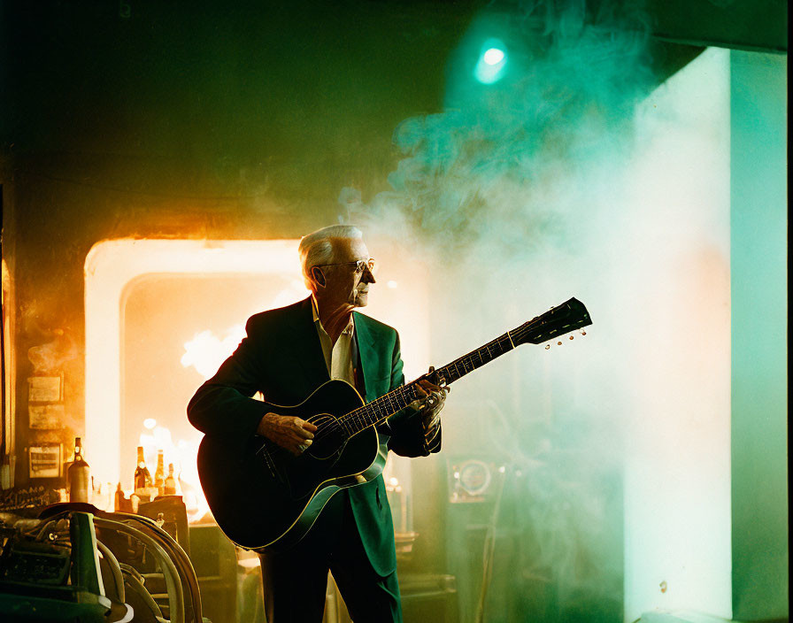 Elderly man in suit playing acoustic guitar on smoky stage