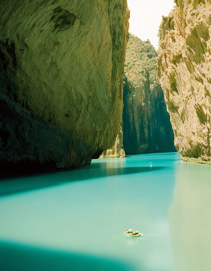 Turquoise River in Rocky Canyon with Small Boat and Person