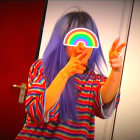 Blue-haired person with rainbow disc and colorful shirt against red curtains