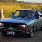 Vintage Blue Car with Twinkling Lights and Weeping Willows at Dusk