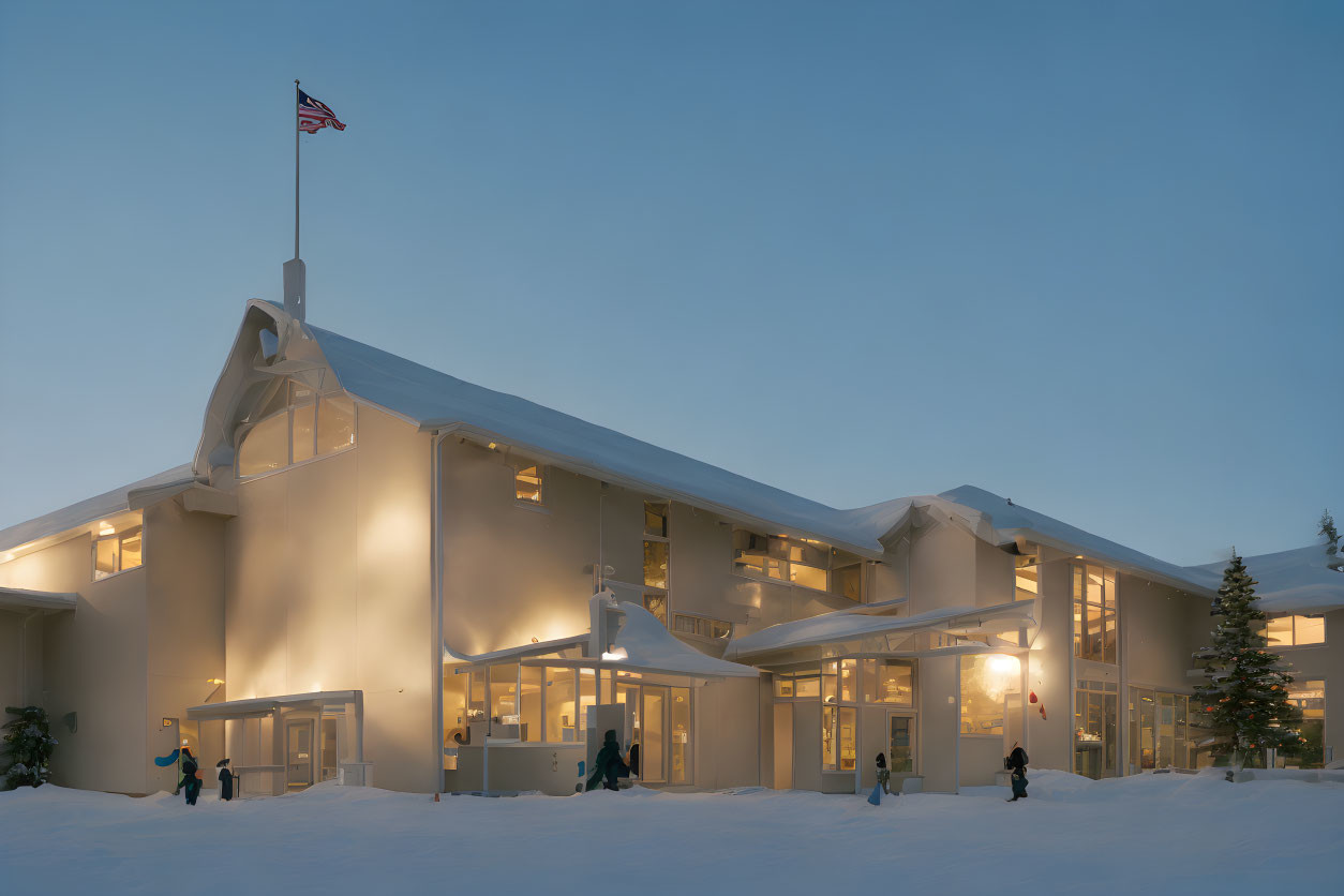 Modern building with large windows in snowy dusk scene with American flag and people outside.