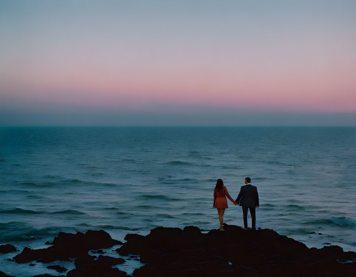 Couple on Seaside Cliffs at Twilight overlooking Ocean