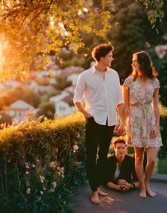 Three People Posing Outdoors at Sunset Among Lush Greenery