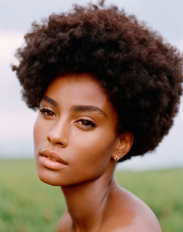 Natural Afro Woman Portrait with Subtle Makeup in Soft-focus Background