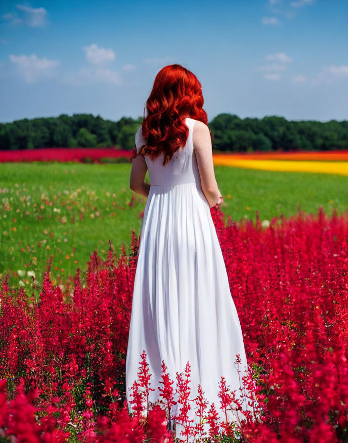 Red-Haired Woman in White Dress Surrounded by Flowers and Blue Sky