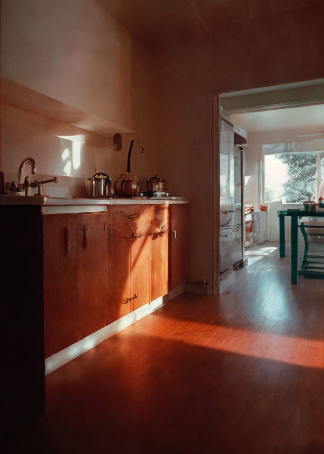 Warm sunlight illuminates cozy kitchen with wooden cabinets and appliances