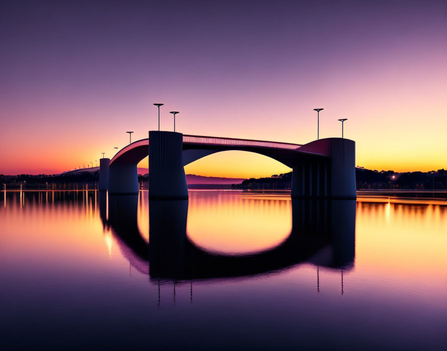 Modern bridge reflecting on calm water at twilight