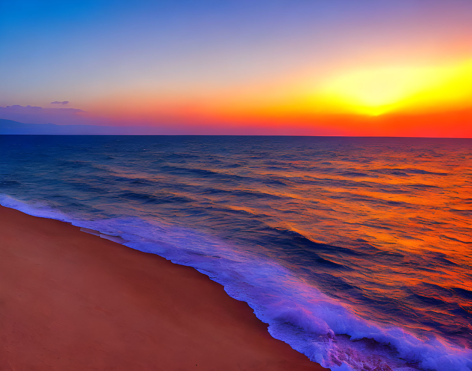 Scenic beach sunset with orange to blue hues reflecting on ocean