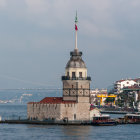 Historical port scene with sailing ships, clock tower, and bustling commerce.