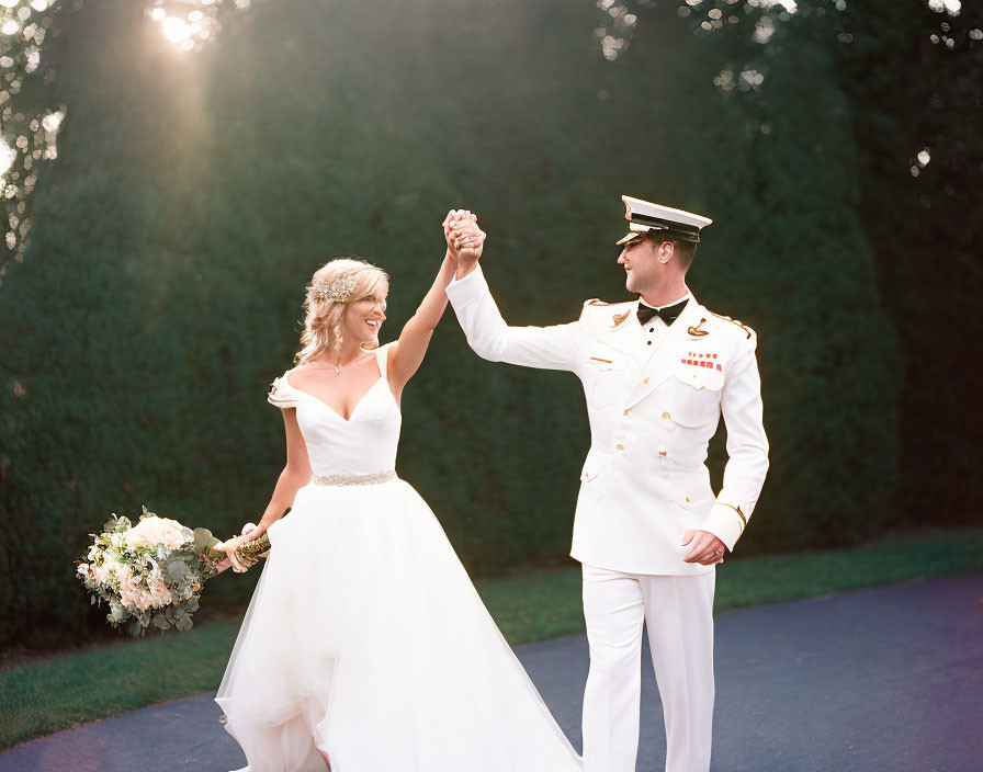 Bride and groom in wedding attire with military groom in sunny outdoor setting