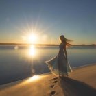 Woman in Colorful Skirt Walking on Beach at Sunset