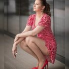 Woman in colorful floral outfit sitting on stone ledge