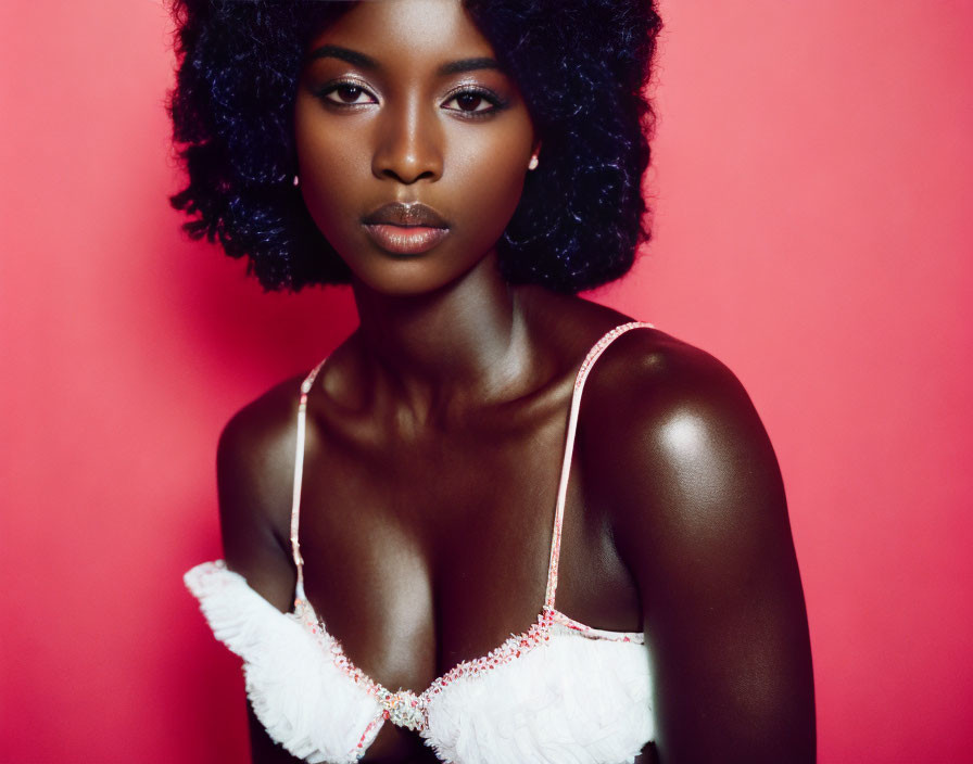 Dark Curly-Haired Woman in White Top on Pink Background