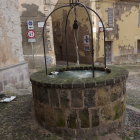 Stone well with whimsical objects near quaint buildings