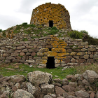 Watercolor illustration of ancient stone watchtower on grassy hill