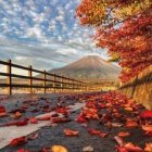 Tranquil lakeside scene with boats, dock, autumn trees, flowers, mountain