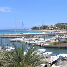 Tranquil marina scene with sailboats, calm waters, and coastal buildings