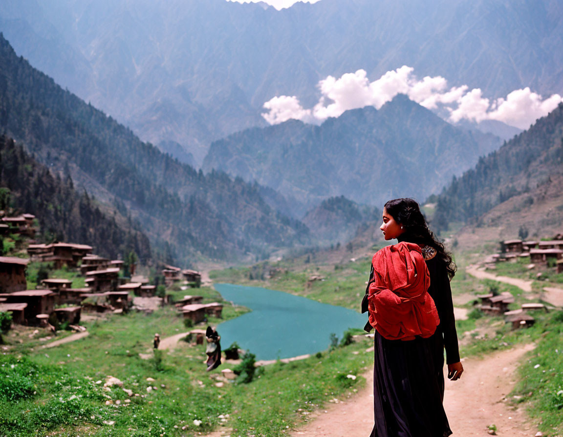 Woman with Red Backpack Overlooking Serene Mountain Village