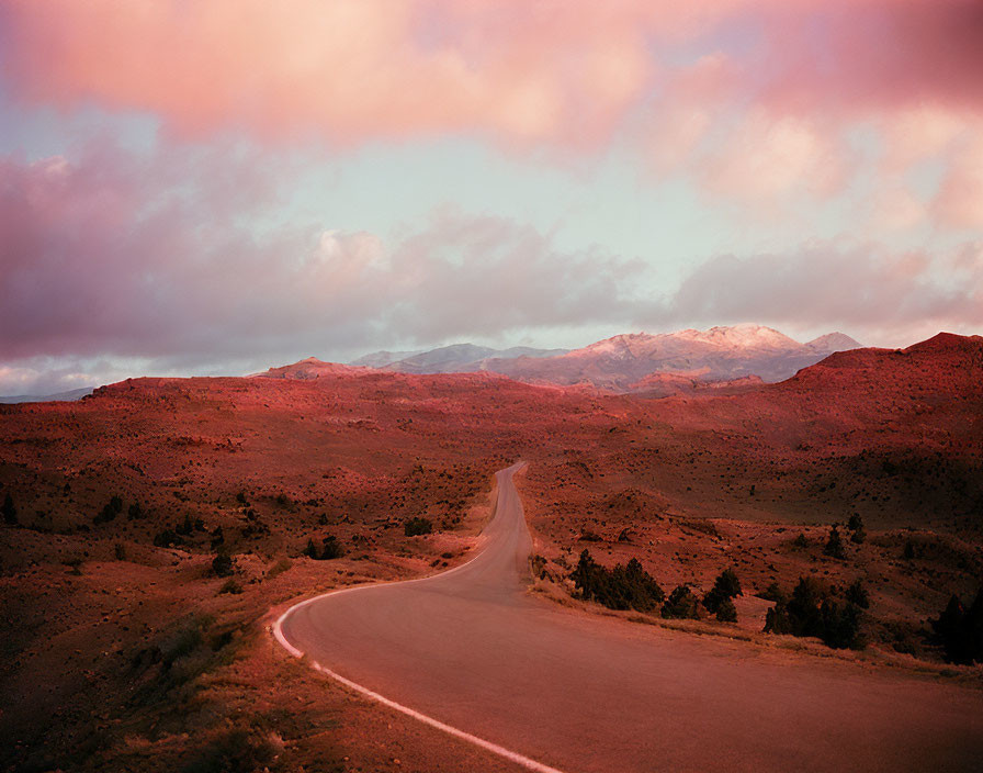 Scenic winding road in hilly desert landscape at sunset