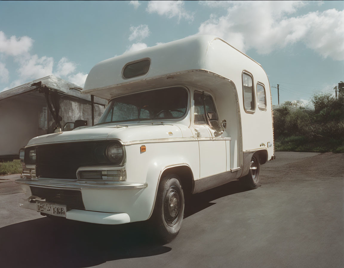 Classic White Motorhome Parked Outdoors with Buildings in Background