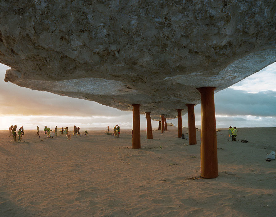 Huge Balanced Rock on Stone Pillars with People at Sunset