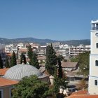 Panoramic cityscape blending traditional and modern architecture under clear blue sky