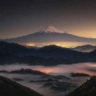 Starry sky over Mount Fuji and mist-covered mountains