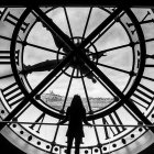 Person admires colorful landscape through large clock window