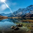 Alpine landscape with blue river, snowy mountains, and bright flora