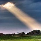 Tranquil sunset landscape with crepuscular rays and rolling hills