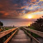 Scenic wooden pier with street lamps at sunset over calm water