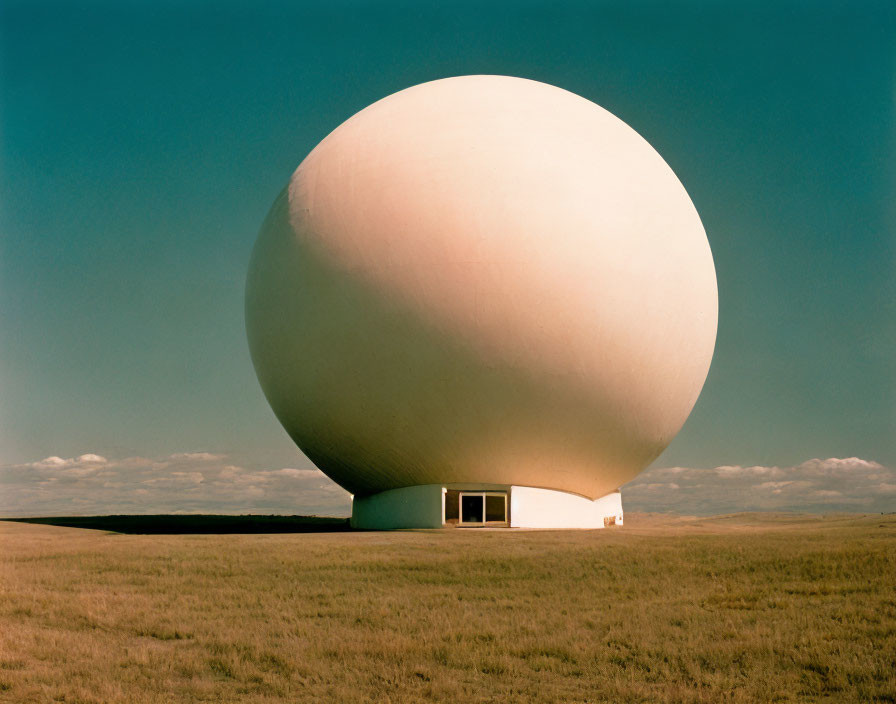 Spherical Structure on Grassy Landscape under Blue Sky