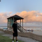 Person on Sandy Beach at Sunset with Footsteps in Sand