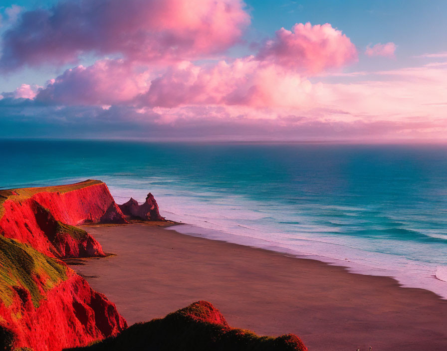 Scenic sunset view of pink clouds, blue ocean, red cliffs, and green vegetation