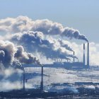 Industrial factories emitting smoke in mountainous landscape