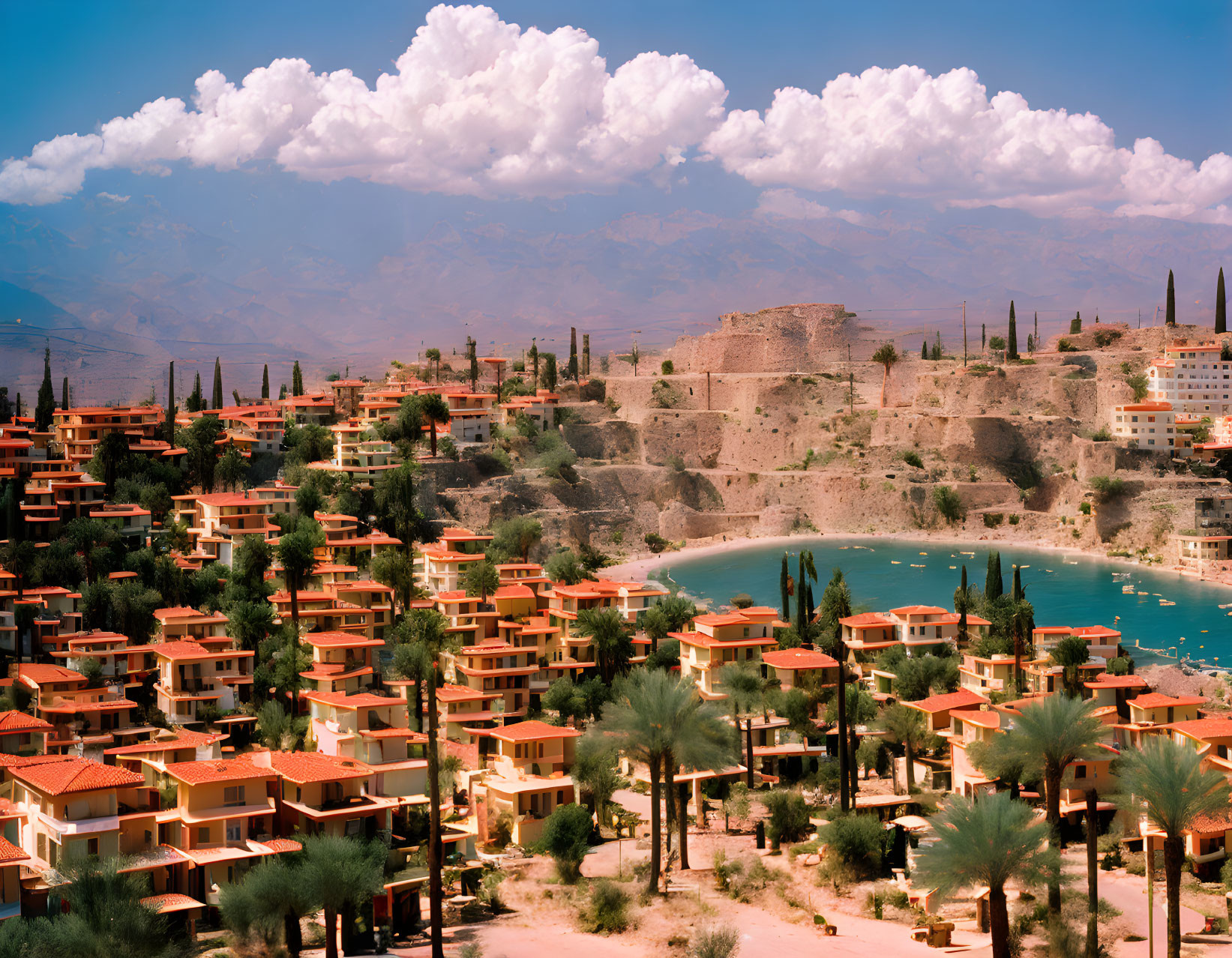 Scenic lakeside town with terracotta-roofed houses, lush greenery, and rocky