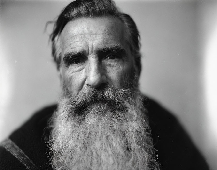 Elderly man with full white beard and mustache, deep-set eyes and prominent brow