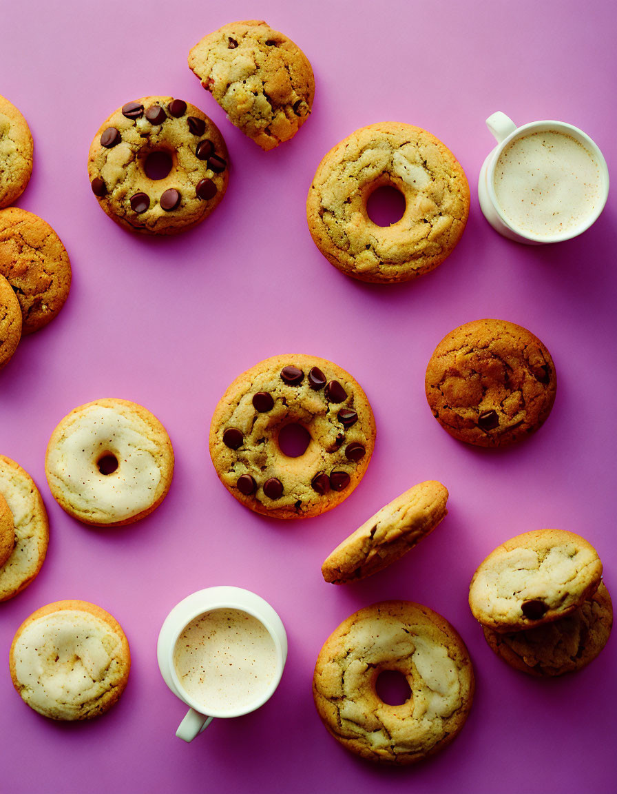 Coffee and cookies on pink surface.