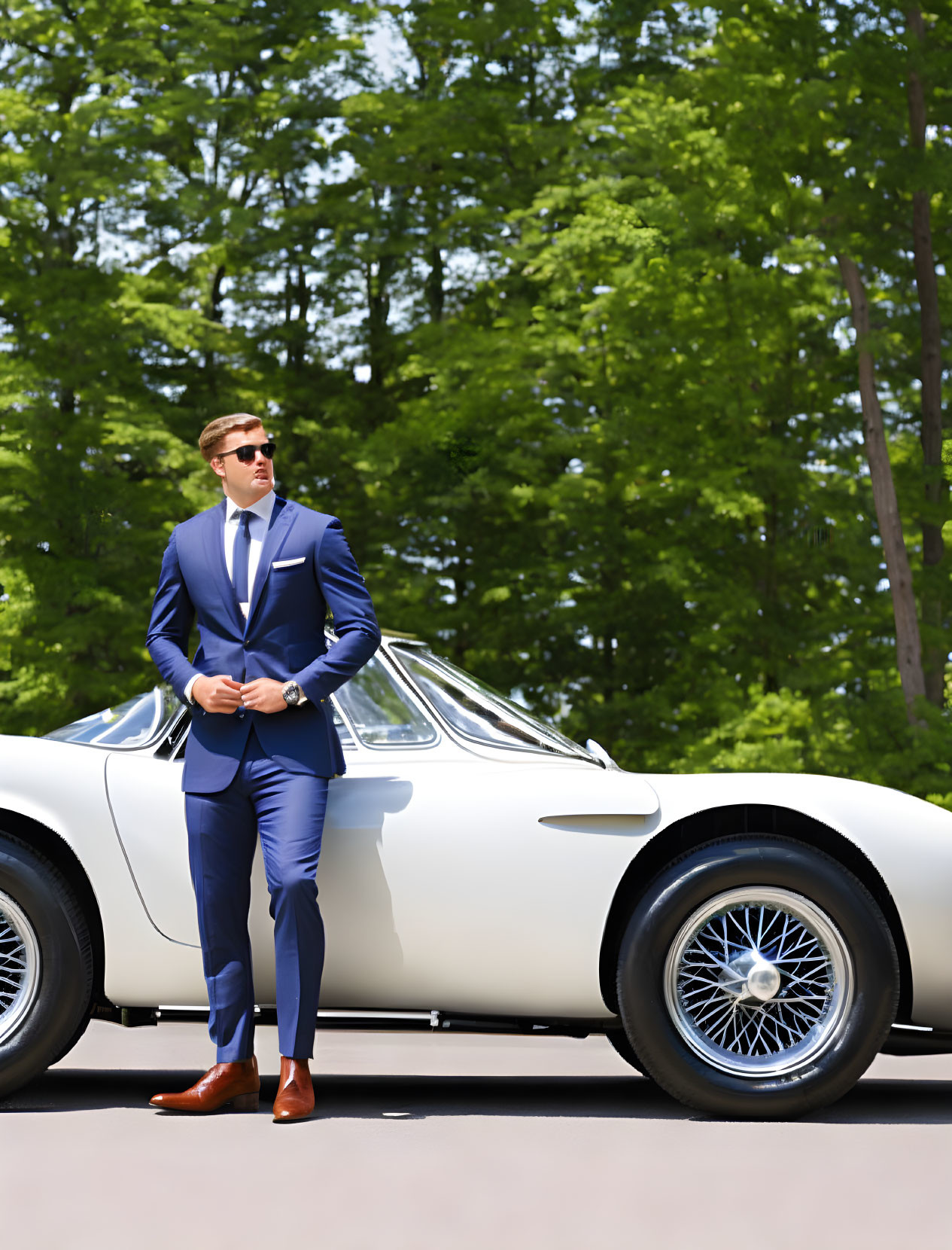 Confident man in blue suit next to white sports car under sunny skies