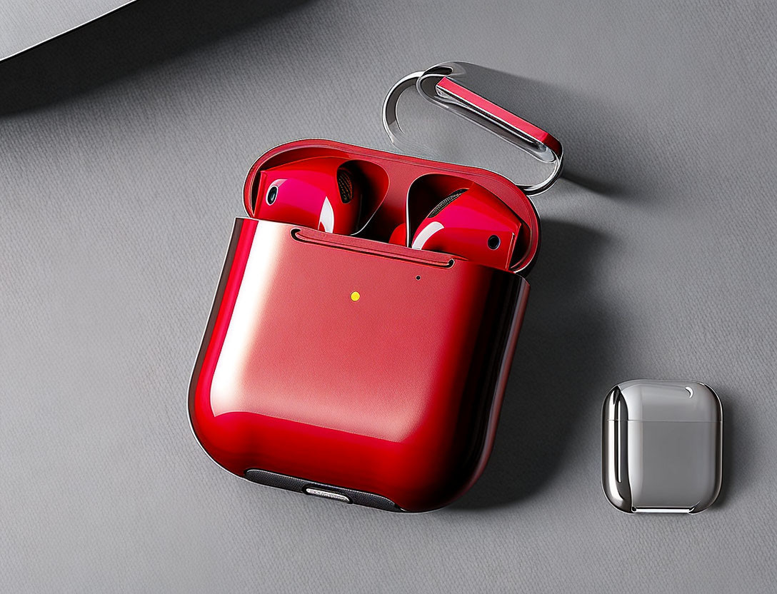 Red wireless earbuds and matching case on gray surface with silver earbud case.